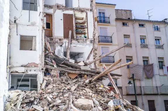 A crumbling residential building with collapsed floors