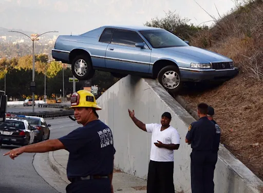 Car crashed into interstate wall with firefighters and people pointing.
