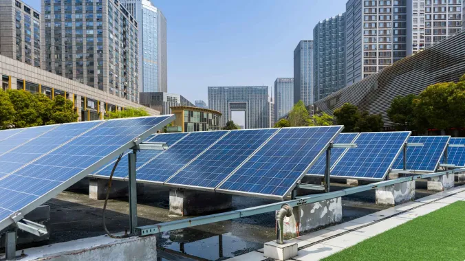 solar panels on roof with large buildings in the background