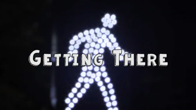 pedestrian traffic signal with text "Getting There" 