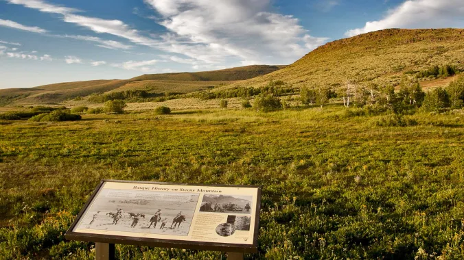 interpretive sign in the foreground with nature and hills in the background