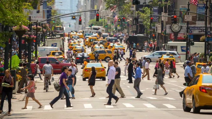 busy street with pedestrians, cars, and streetlights in New York