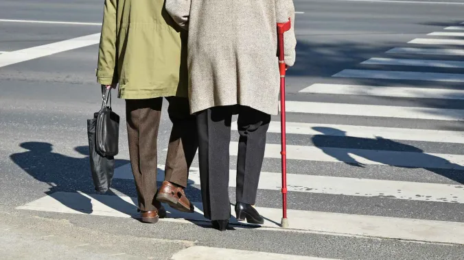 two elderly people crossing the street