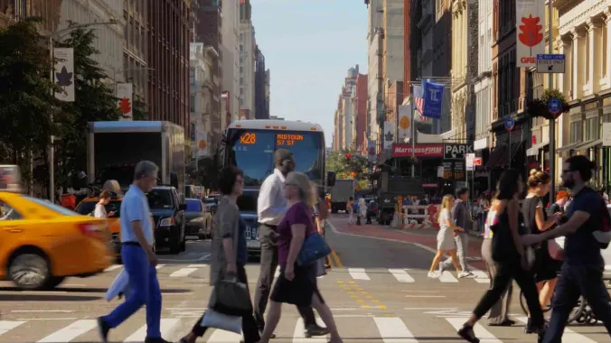 pedestrians crossing busy urban intersection