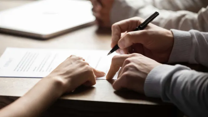 closeup of hands signing documents