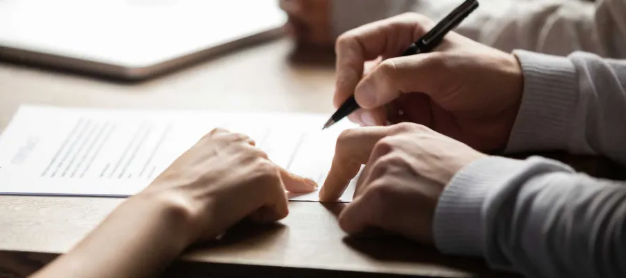 closeup of hands signing documents