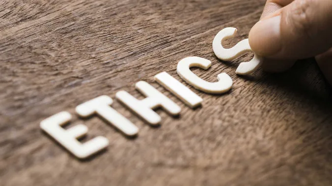 hand placing letters down spelling out ethics