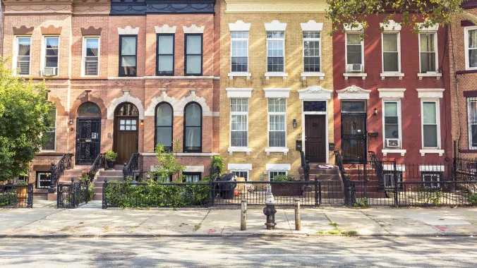 frontal view of different colored apartments lined on street