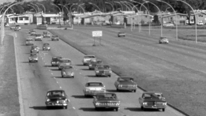 cars on highway with suburb in background