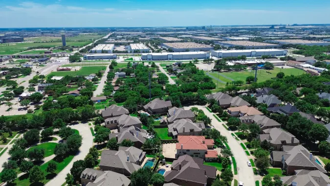 Image of a suburban area skyline birdeye view with houses, commercial buildings, and greenery
