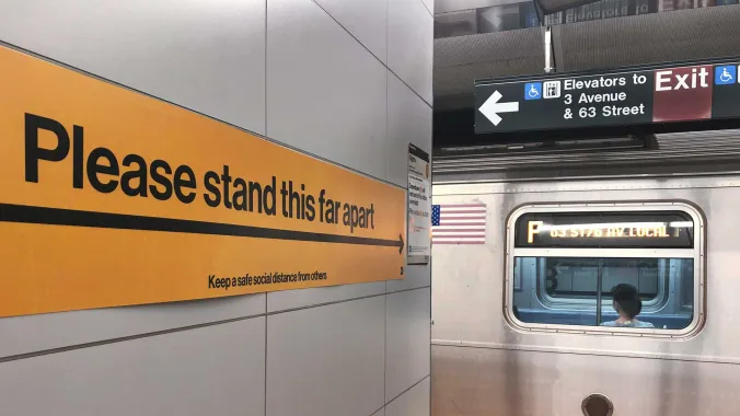 sign in subway station that reads "Please stand this far apart"