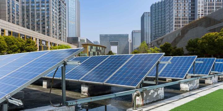 solar panels on roof with large buildings in the background