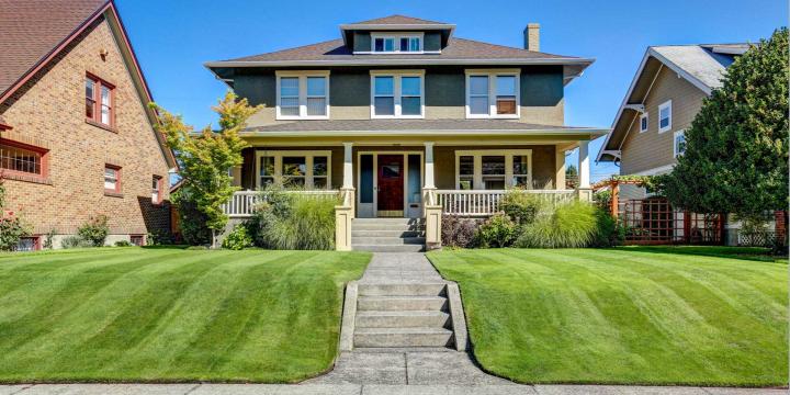 two-story craftsman style home with a green lawn
