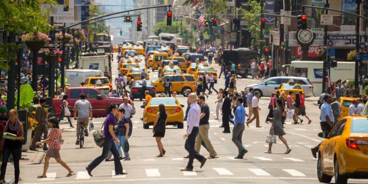 busy street with pedestrians, cars, and streetlights in New York