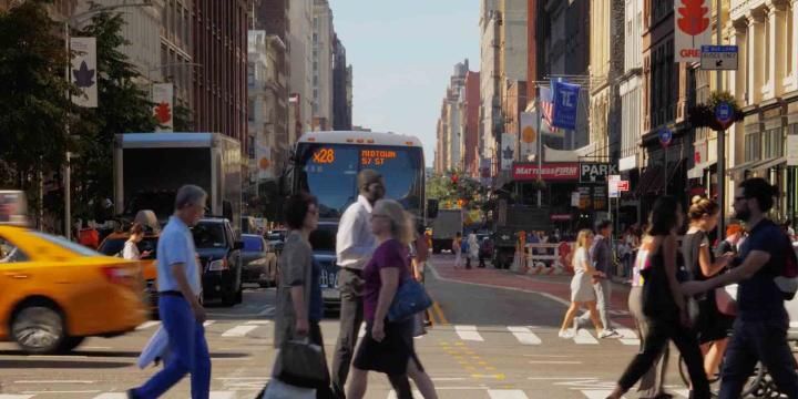 pedestrians crossing busy urban intersection