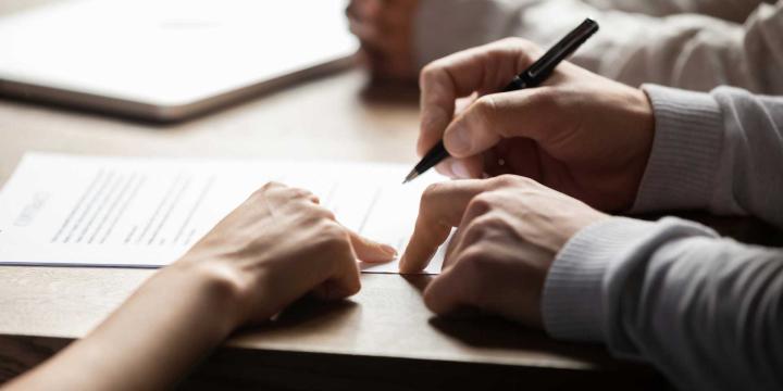 closeup of hands signing documents