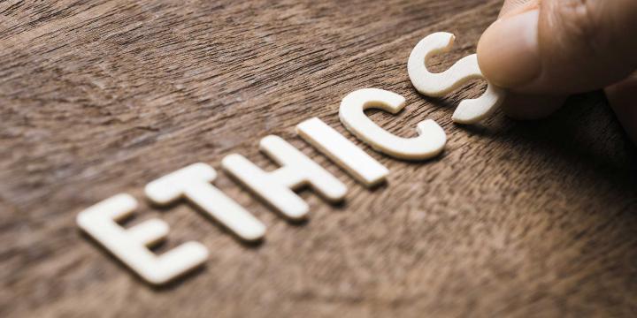 hand placing letters down spelling out ethics