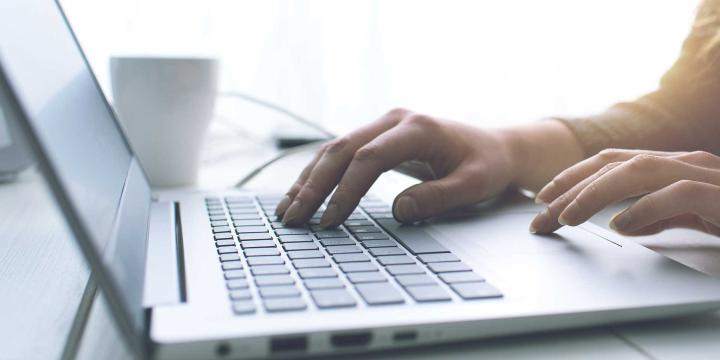 closeup of hands typing on laptop