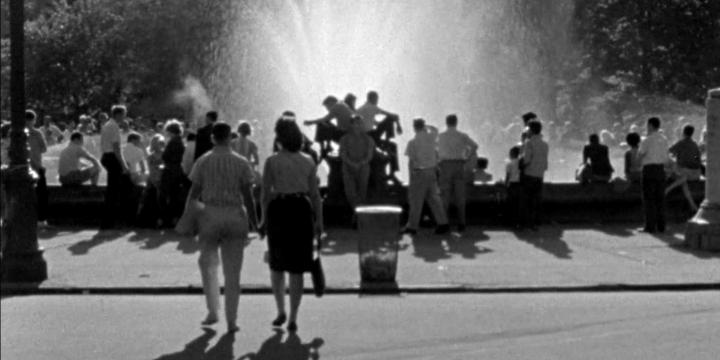 large city fountain surrounded by people