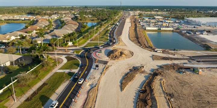Bird-eye view of a freeway in constructions alongside a housing district