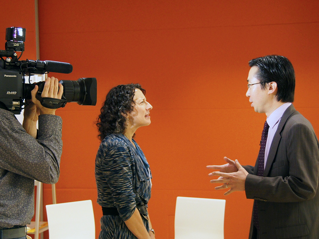 cameraman filming man and woman speaking to each other